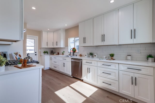 kitchen featuring white cabinetry, dishwasher, sink, and a wealth of natural light