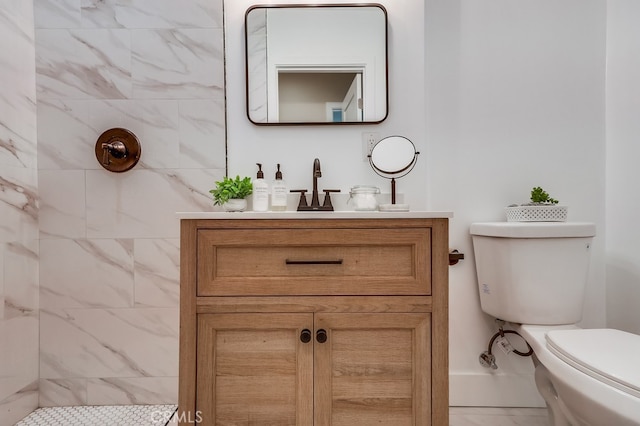 bathroom featuring vanity, tiled shower, and toilet