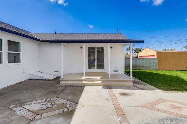 back of house featuring a patio and a lawn