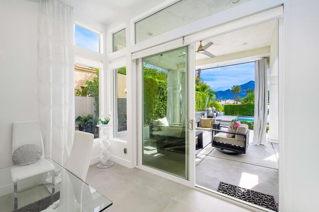 doorway with ceiling fan and a mountain view