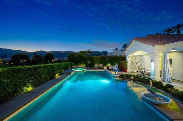 pool at dusk featuring a mountain view