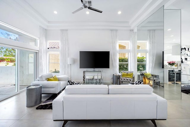 living room featuring a high ceiling, a raised ceiling, and ceiling fan