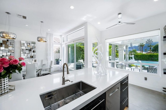 kitchen with pendant lighting, stainless steel dishwasher, sink, and a wealth of natural light