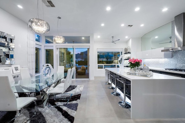 dining space with ceiling fan with notable chandelier