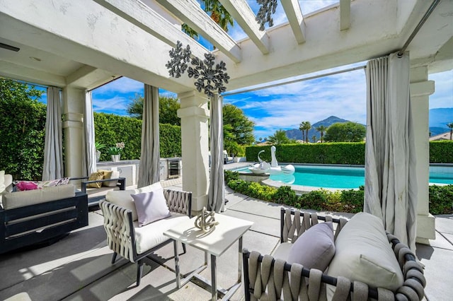 view of patio / terrace featuring a fenced in pool, a mountain view, and an outdoor living space