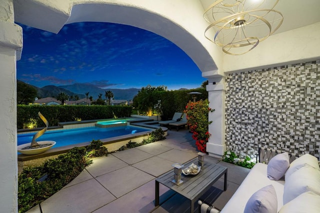 view of swimming pool with a mountain view and a patio area