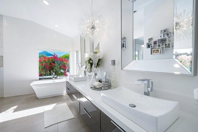 bathroom with lofted ceiling, a bathing tub, vanity, and a wealth of natural light