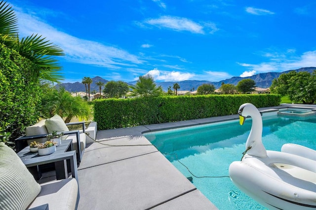 view of pool with an in ground hot tub and a mountain view