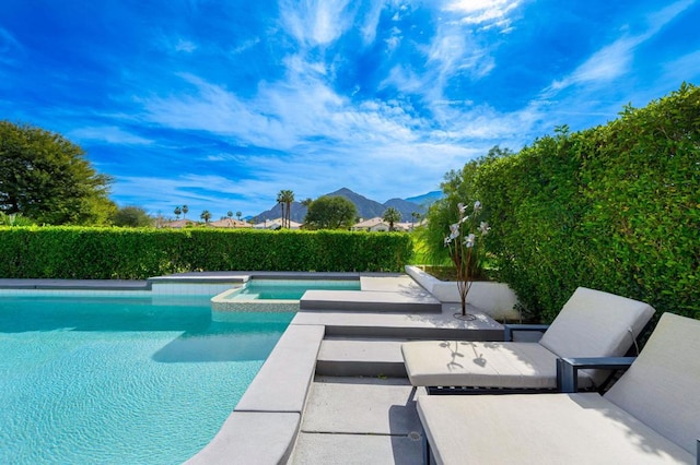 view of swimming pool featuring an in ground hot tub and a mountain view