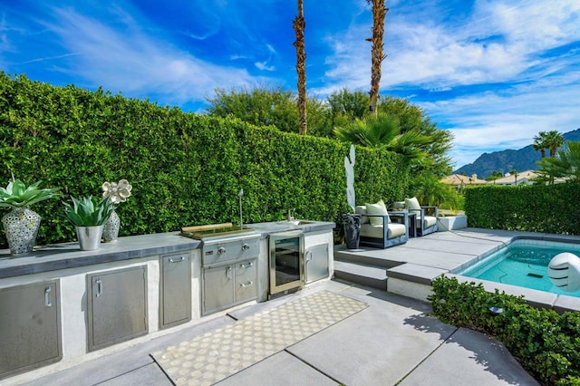 view of patio featuring grilling area, exterior kitchen, and a mountain view