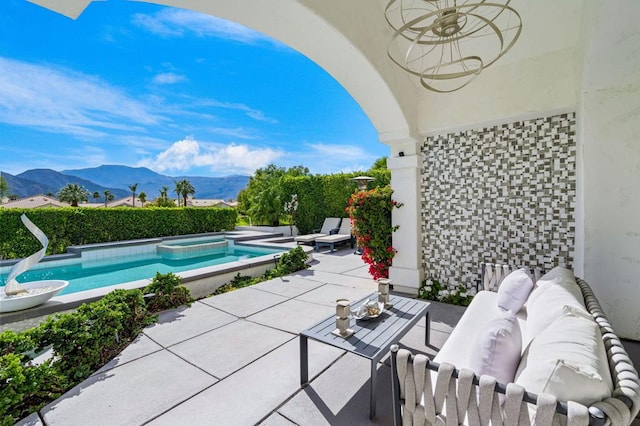 view of patio featuring ceiling fan, a swimming pool with hot tub, outdoor lounge area, and a mountain view