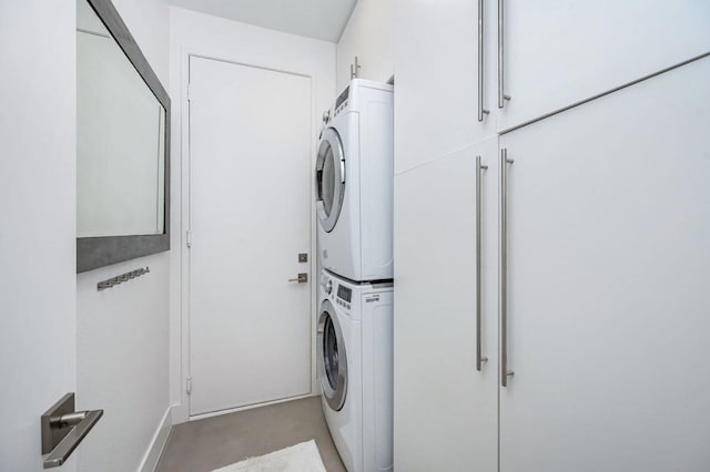 washroom with stacked washer and dryer and cabinets