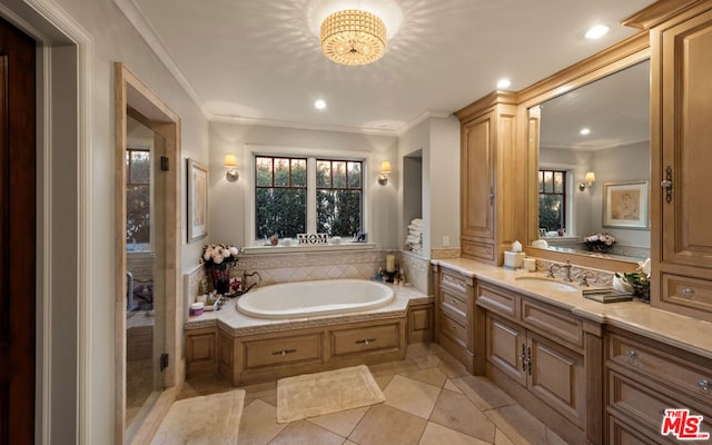 bathroom featuring tile patterned flooring, crown molding, vanity, and a tub to relax in