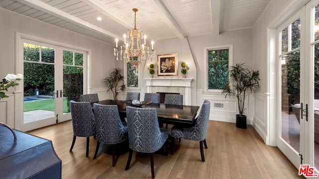 dining space featuring a wealth of natural light, french doors, beamed ceiling, and light wood-type flooring