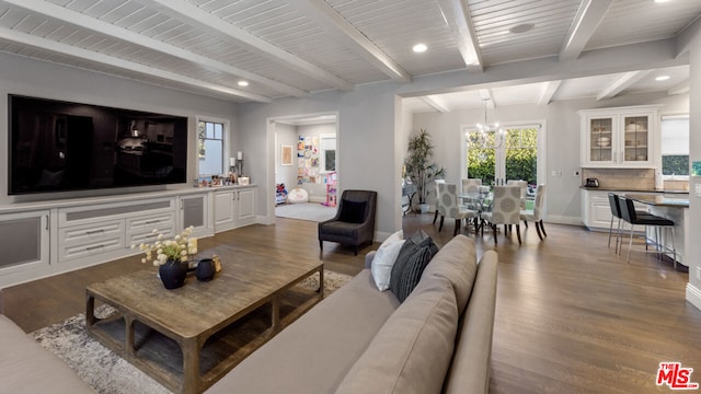 living room with dark hardwood / wood-style flooring, a notable chandelier, and beam ceiling