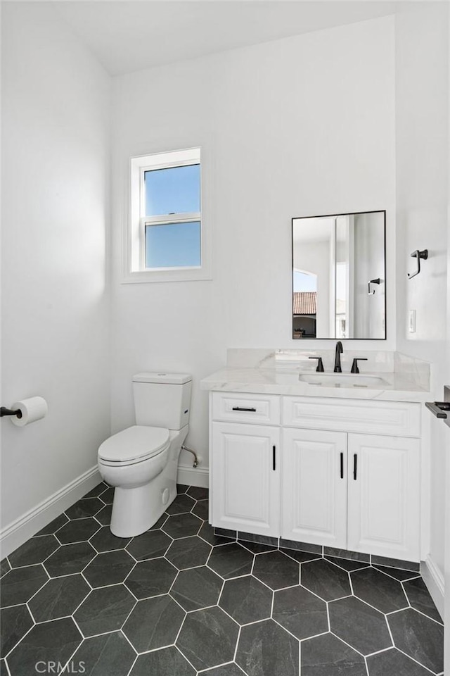 bathroom featuring vanity, tile patterned flooring, and toilet