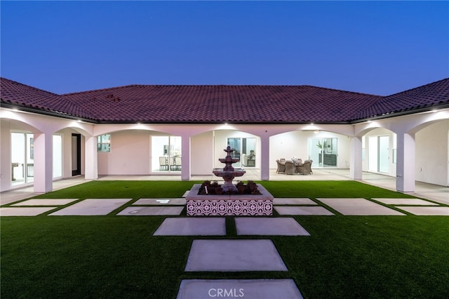 rear view of property featuring a lawn