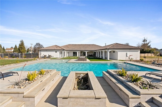 view of swimming pool with a fire pit and a patio area