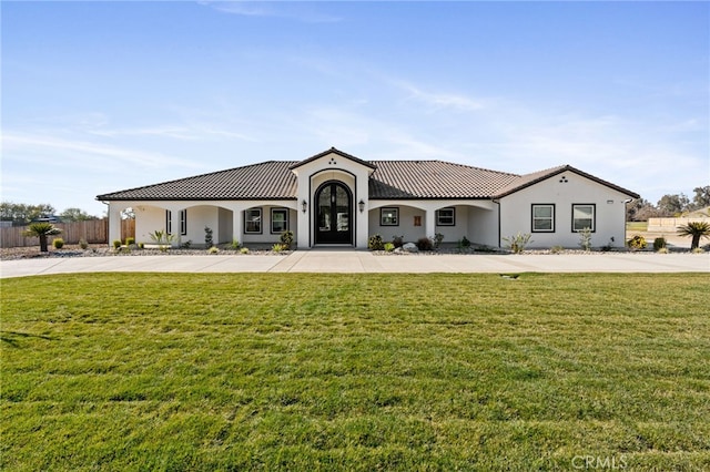 mediterranean / spanish home featuring a front lawn