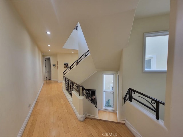 hall with stairs, recessed lighting, baseboards, light wood finished floors, and a wealth of natural light