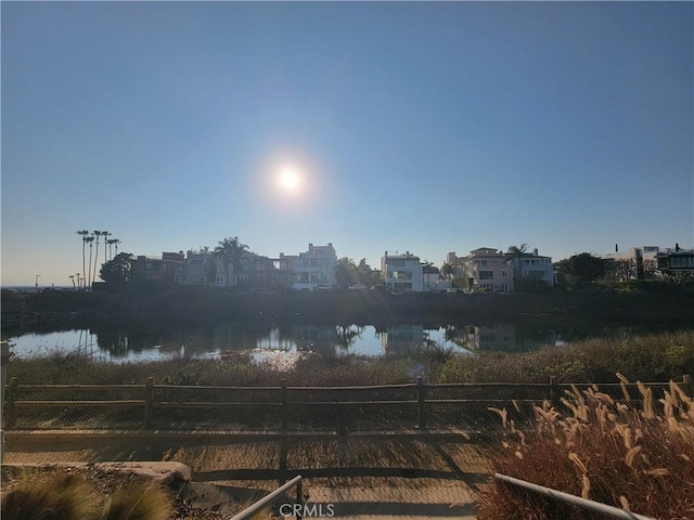 exterior space featuring a water view and fence
