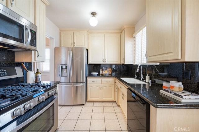 kitchen featuring light tile patterned flooring, sink, dark stone countertops, decorative backsplash, and stainless steel appliances