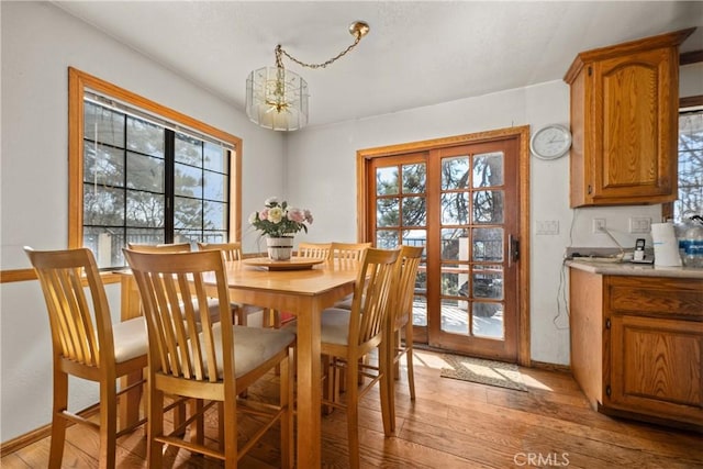 dining space featuring a healthy amount of sunlight, a chandelier, and light hardwood / wood-style floors