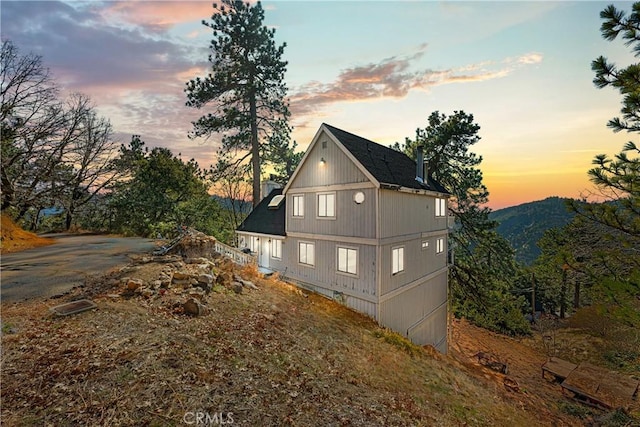 property exterior at dusk featuring a mountain view