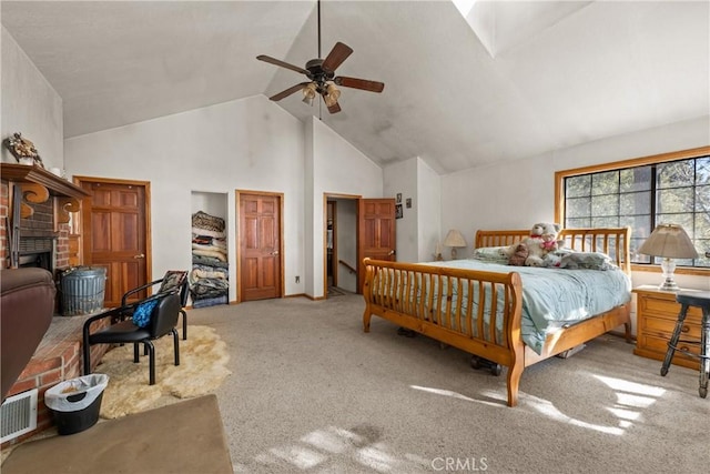 bedroom with ceiling fan, light colored carpet, a fireplace, and high vaulted ceiling