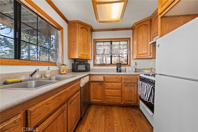 kitchen with crown molding, sink, white appliances, and light hardwood / wood-style flooring