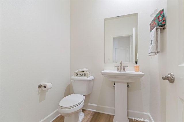 bathroom with hardwood / wood-style flooring and toilet