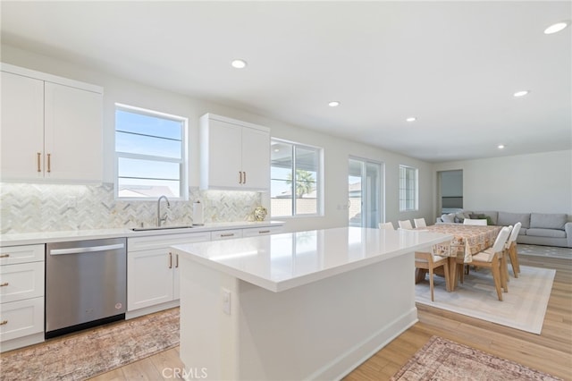 kitchen featuring white cabinetry, dishwasher, sink, and a wealth of natural light