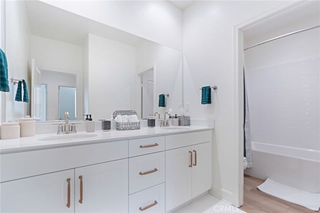 full bathroom featuring vanity, hardwood / wood-style flooring, bathtub / shower combination, and toilet