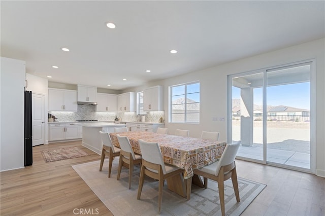 dining space with sink and light hardwood / wood-style floors