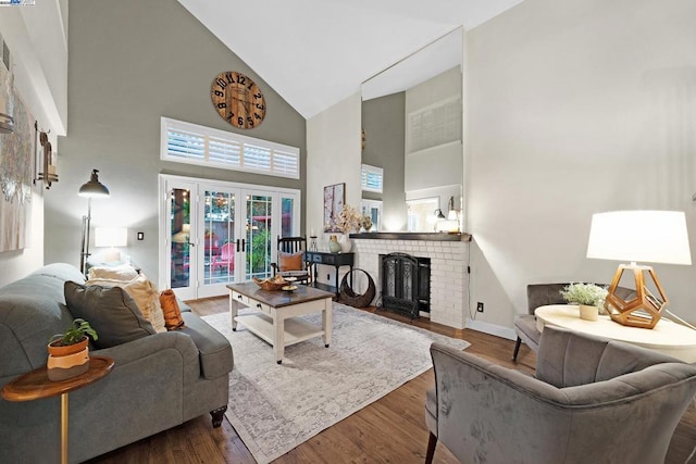 living room with hardwood / wood-style floors, a fireplace, high vaulted ceiling, and french doors