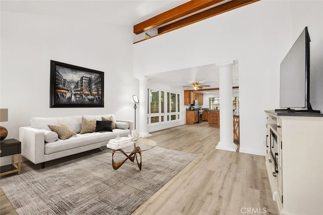 living room featuring ornate columns, ceiling fan, light wood-type flooring, and beamed ceiling