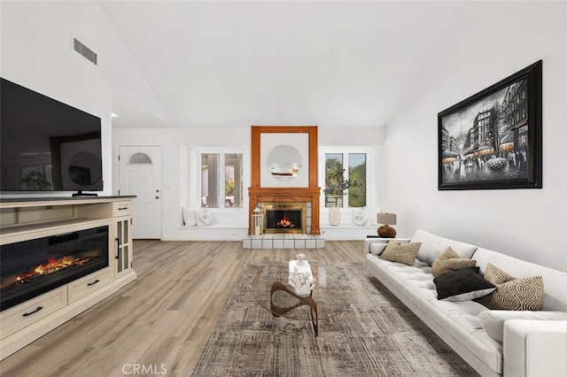 living room with vaulted ceiling and light hardwood / wood-style flooring