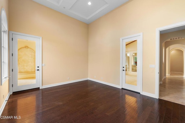 empty room featuring coffered ceiling and dark hardwood / wood-style floors