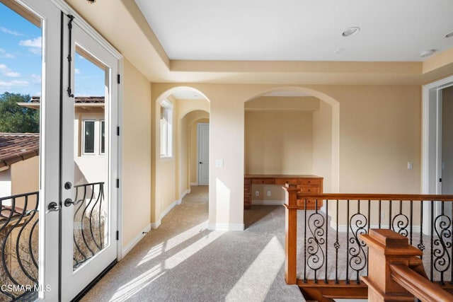 hallway featuring light colored carpet