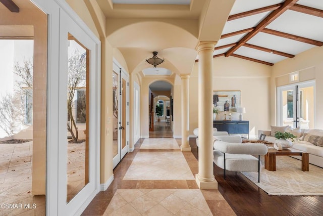 hallway featuring french doors, beam ceiling, high vaulted ceiling, and ornate columns