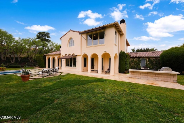 rear view of property with a yard and a patio