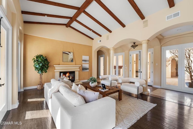 living room with dark wood-type flooring, high vaulted ceiling, beamed ceiling, and ornate columns