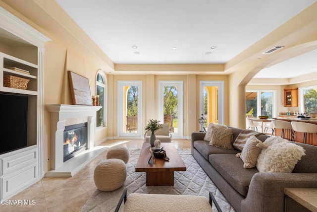 living room featuring built in features and light tile patterned flooring