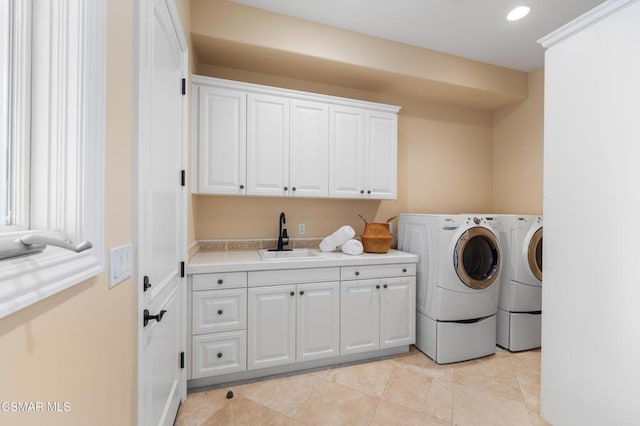 washroom with separate washer and dryer, sink, light tile patterned floors, and cabinets