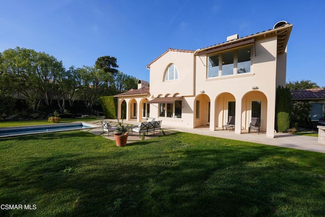 back of house featuring a patio area and a lawn