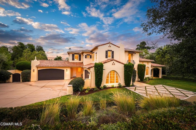 mediterranean / spanish home featuring a garage and a lawn