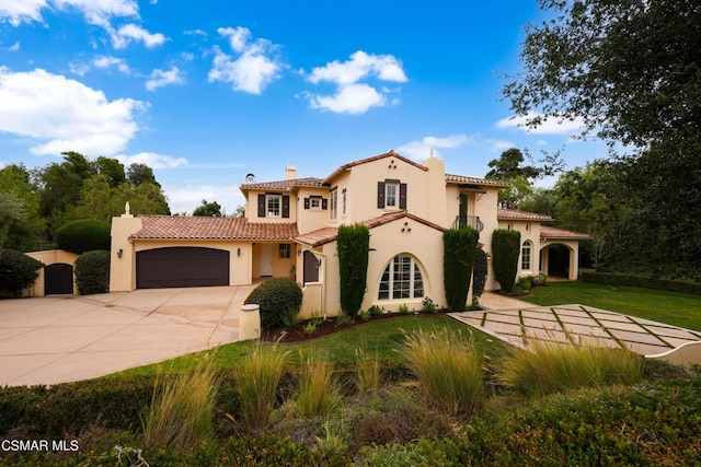 mediterranean / spanish house featuring a garage and a front lawn