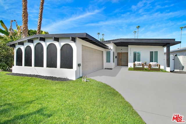 ranch-style home with a garage, an outdoor hangout area, and a front yard