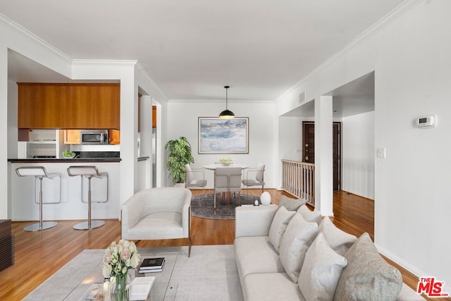 living room with ornamental molding and light hardwood / wood-style flooring