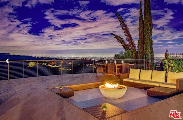 deck at dusk with an outdoor living space with a fire pit